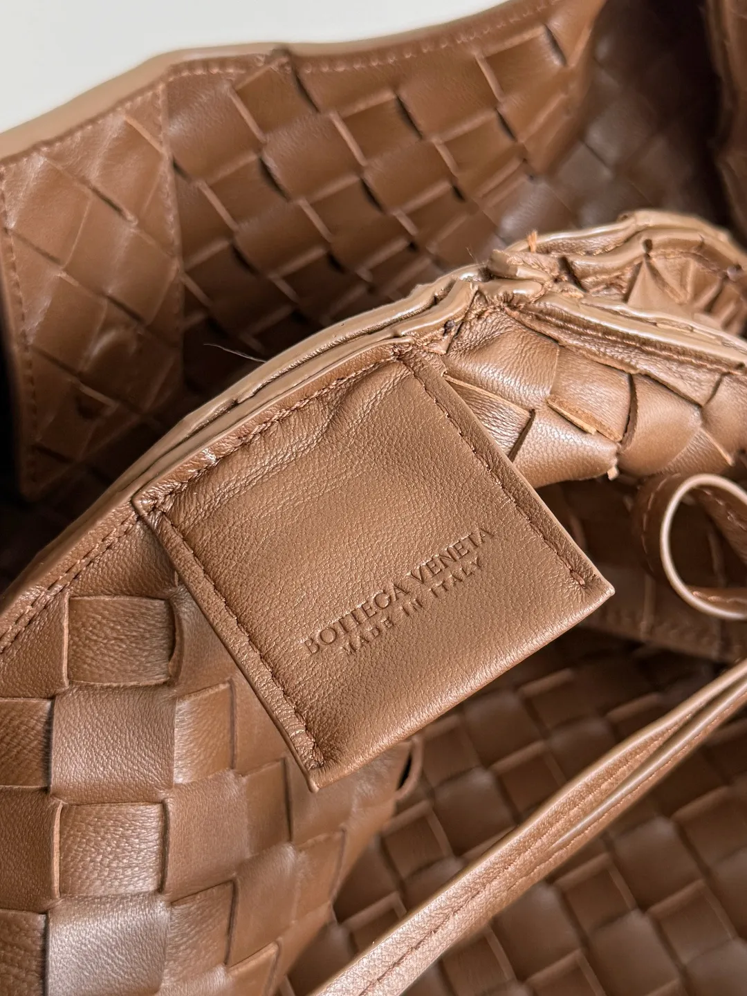 Batch 2760 new products are coming! BOTTEGA VENETA Bottega Veneta's 2025 new Campana shoulder bag is on the market~ First of all, I would like to praise the weight of this bag. As a not too small bag, it is very light for daily use. For people like me who need to carry a lot of belongings when going out, this advantage is great, and it greatly reduces the burden of traveling. 🛍️The shape is a bit like a combination of parachute and jodie. The blunt triangle shape is cute and honest. Carrying it on your back when going shopping is a good mood accelerator. The handles and body of the bag are both classic weaves. A tie is added to the original open design. If it is not tied up, the bag will look like a small vegetable basket when carried. Style number: 844250 Size: 39*24*18.5cm